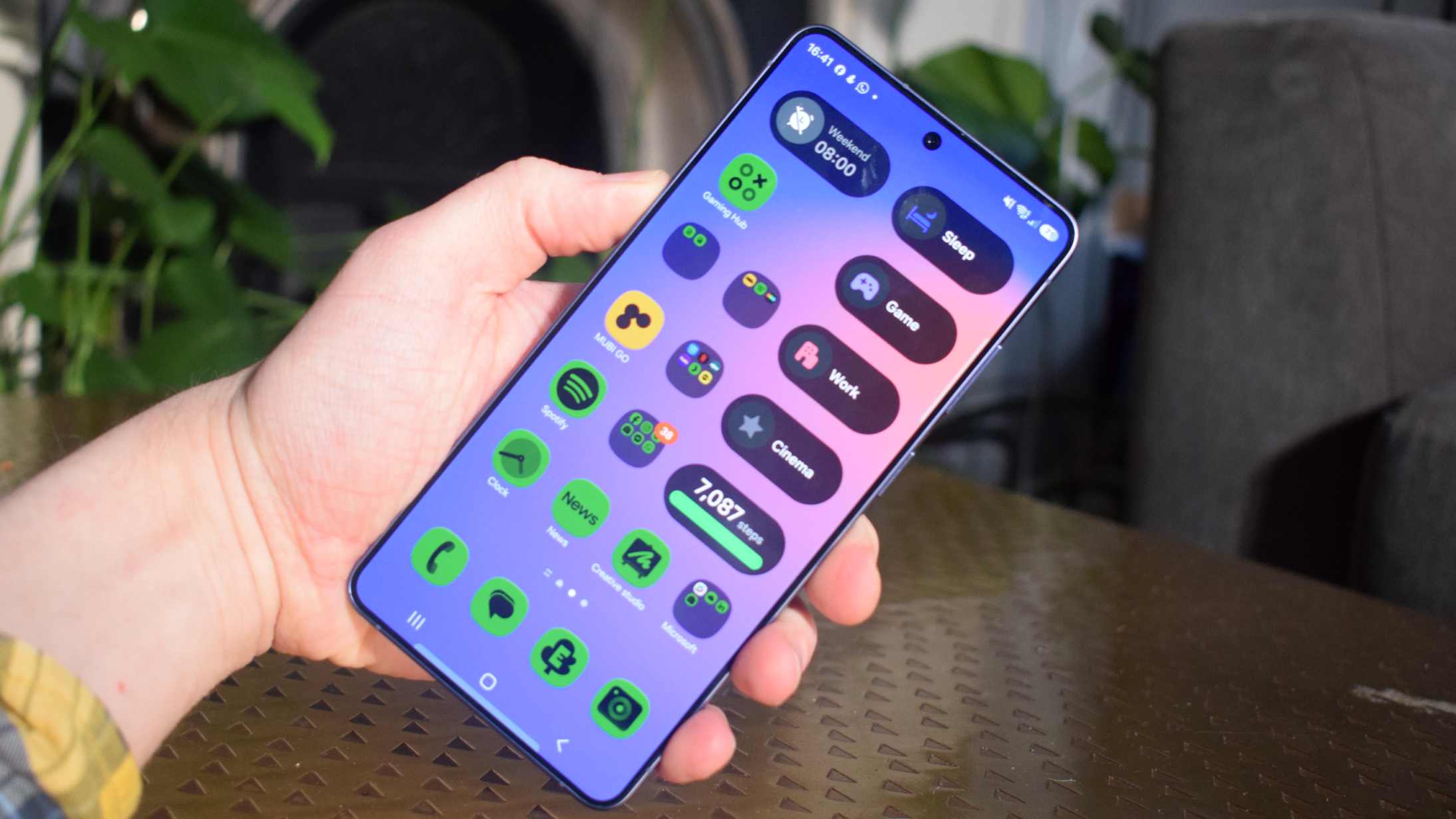 The Samsung Galaxy S26 Ultra in a man's hand, showing a home screen.