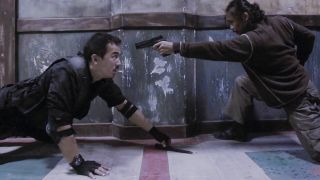 Two fighters take a breath while one holds a gun to the other in The Raid movie