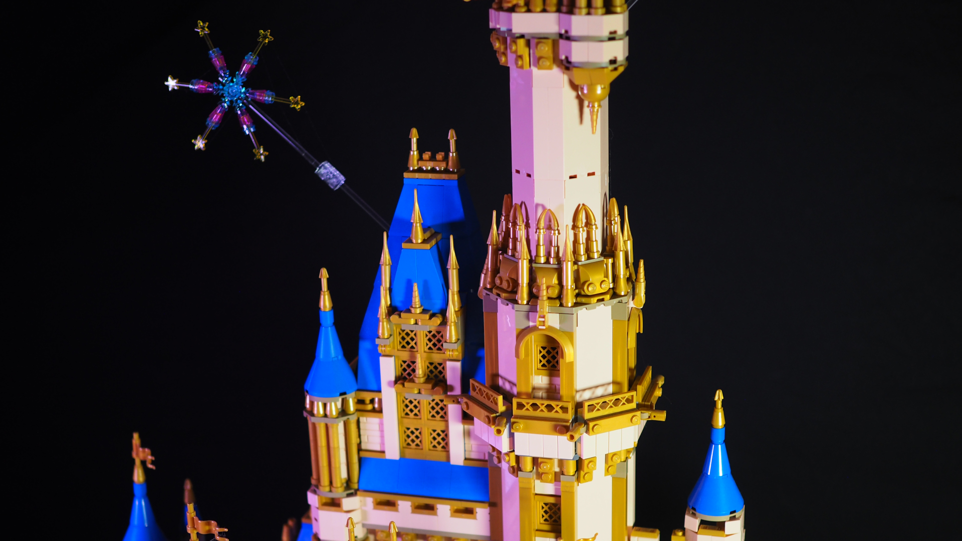 A Lego firework attached to the upper levels of the Lego Disney Castle, against a dark background