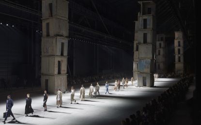 Models walking on runway with concrete towers as a backdrop at Milan's Pirelli Hanger Bicocca