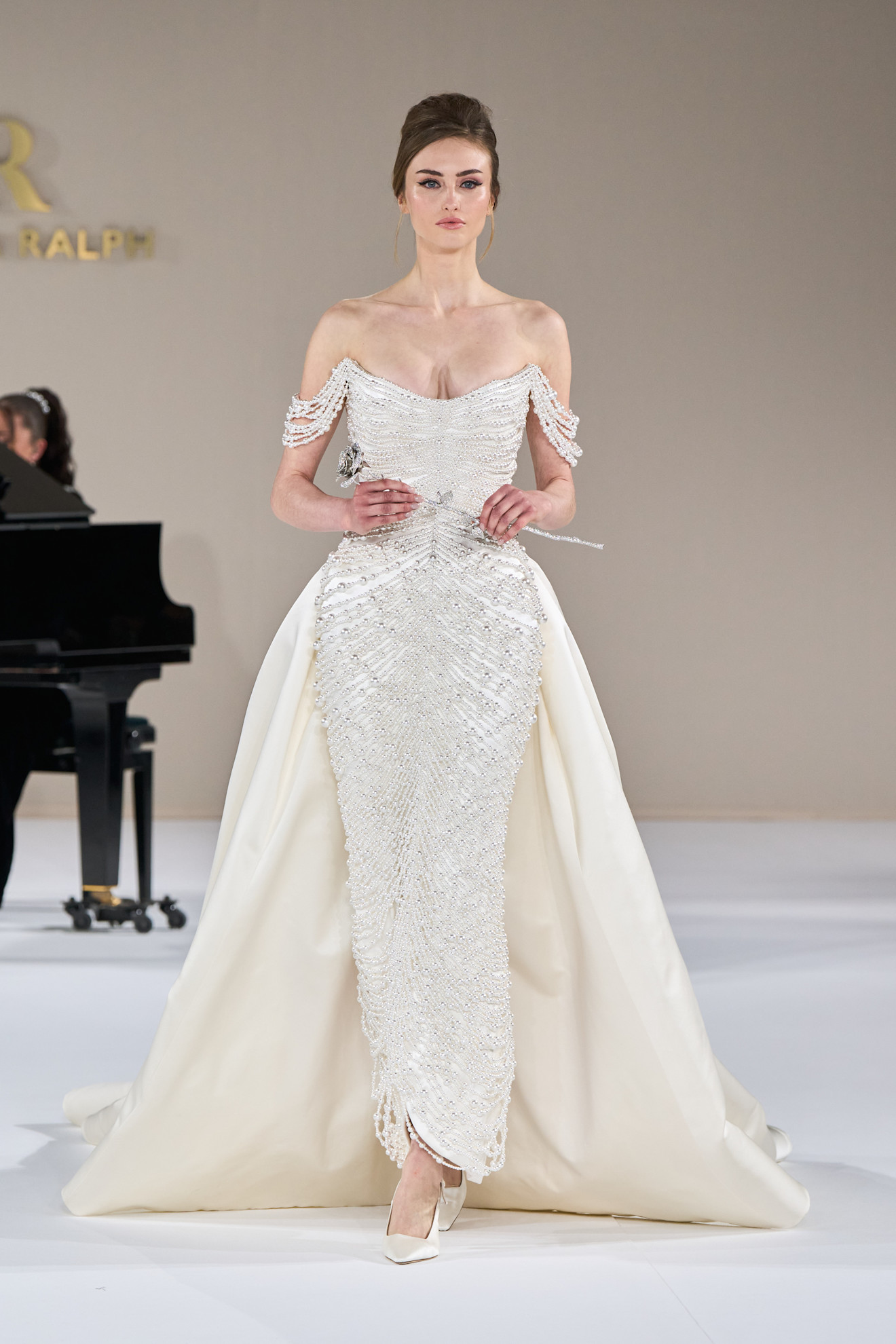 A model wears a pearl-embellished dress on the Tamara Ralph Spring 2025 Couture runway.