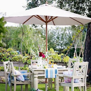 garden area with white umbrella shade and table with chairs