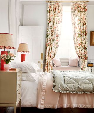 A pretty country house guest bedroom with floral curtains and traditional eiderdown