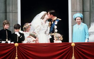 Princess Diana and Prince Charles kissing on the balcony of Buckingham Palace immediately after their wedding ceremony.