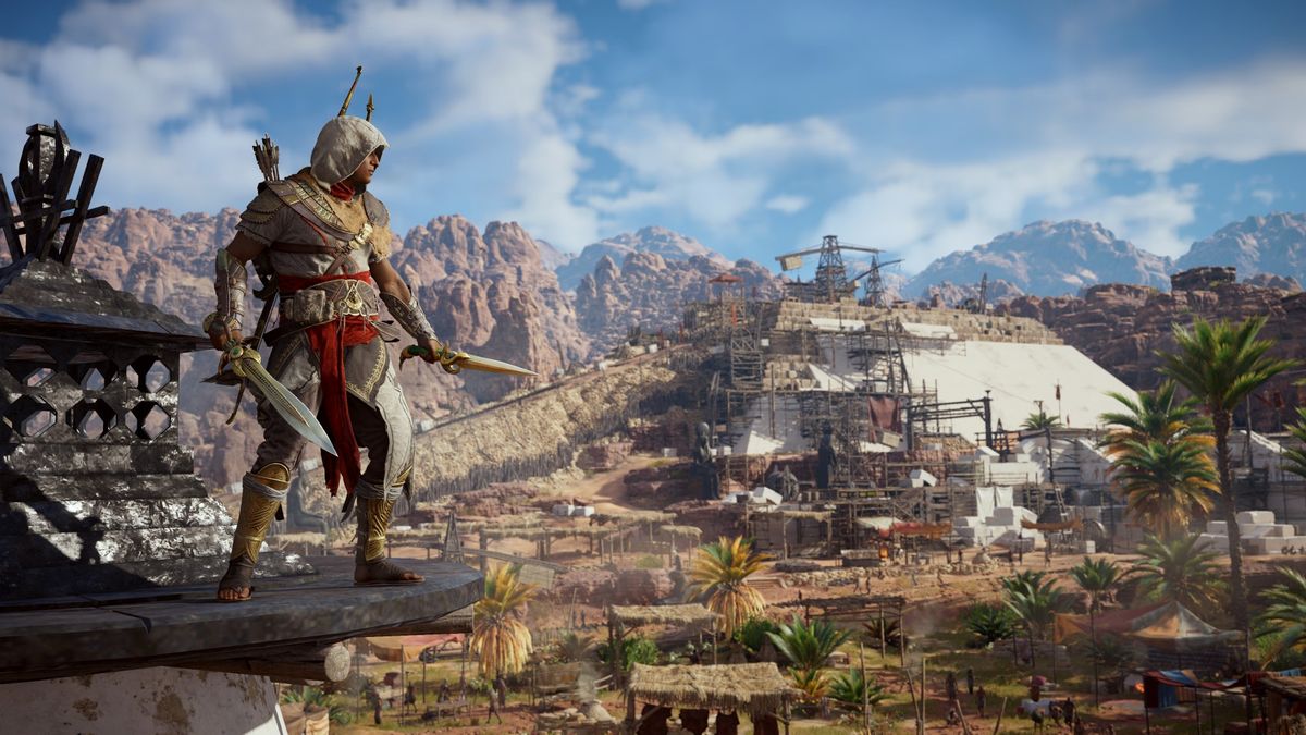 Bayek stands on a ledge in AC Origins