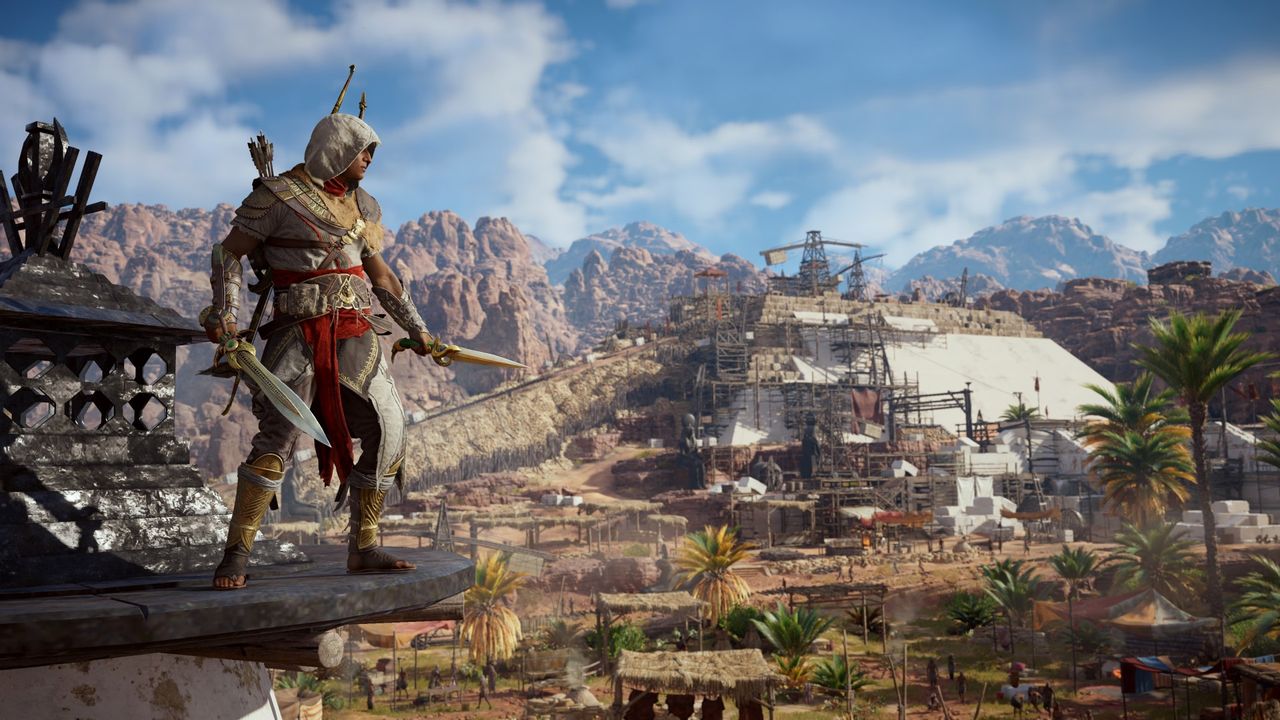 Bayek stands on a ledge in AC Origins