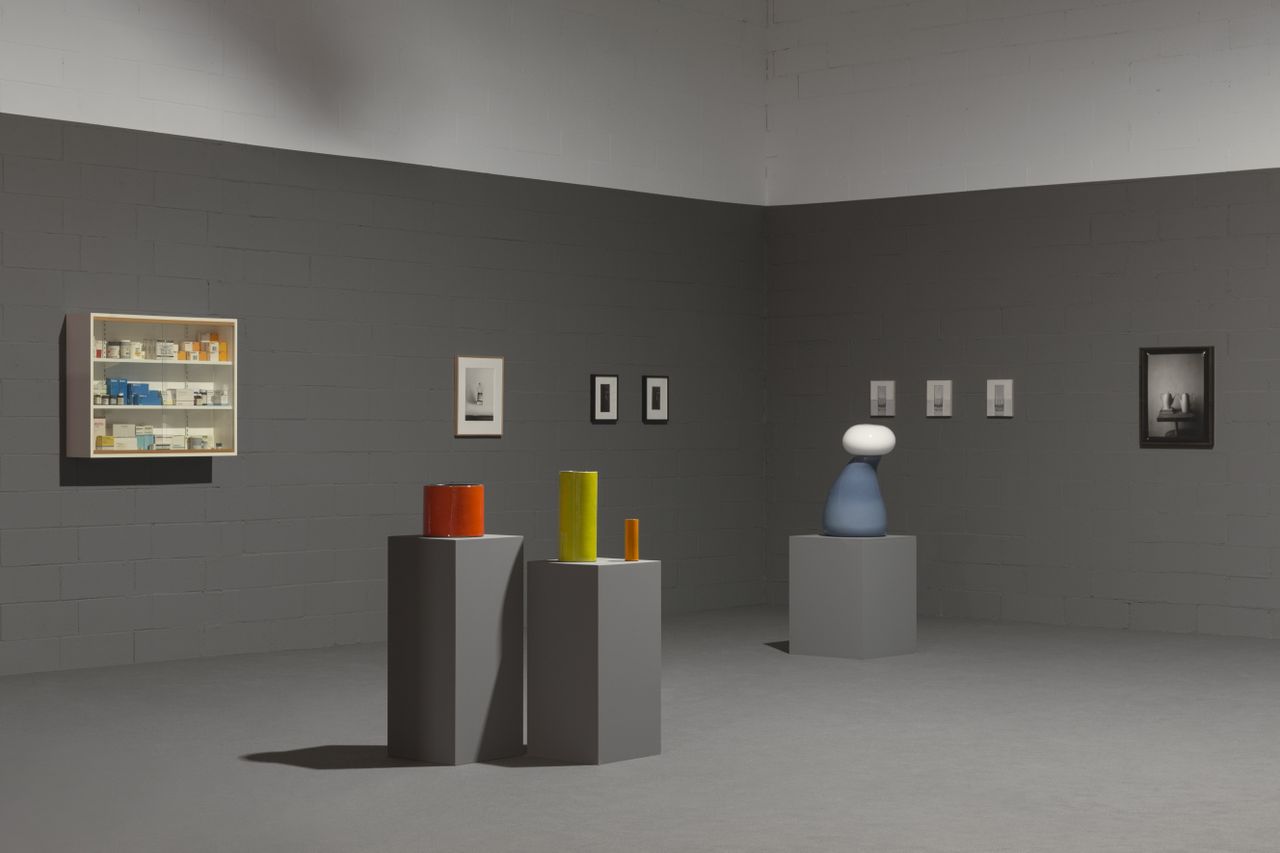 Installation view of Mutina&#039;s Ode to Things exhibition with ceramic vessels on plinths and artworks on walls