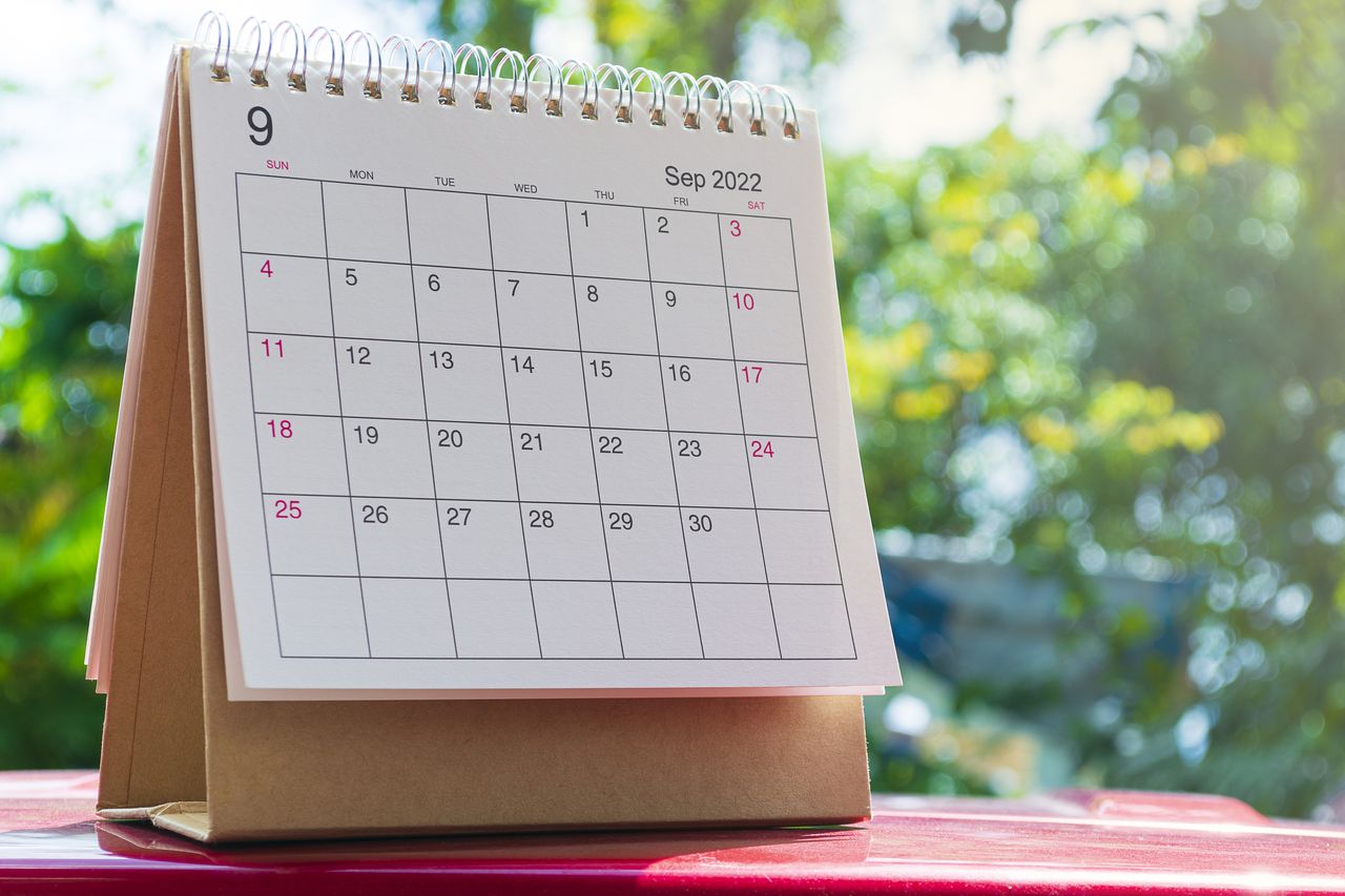 white September calendar against green background of trees