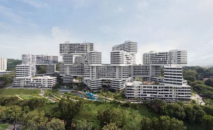 'The Interlace' Singapore's largest new residential development, high rise buildings centre, surrounding areas of trees and grassy areas, blue cloudy sky