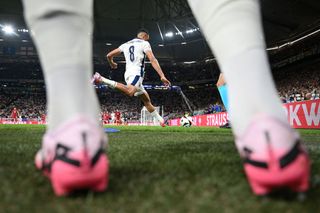 A general view through the legs of a substitute as Trent Alexander-Arnold of England takes a corner kick during the UEFA EURO 2024 group stage match between Serbia and England at Arena AufSchalke on June 16, 2024 in Gelsenkirchen, Germany.