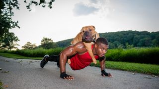 Man doing push-ups with dog on his back