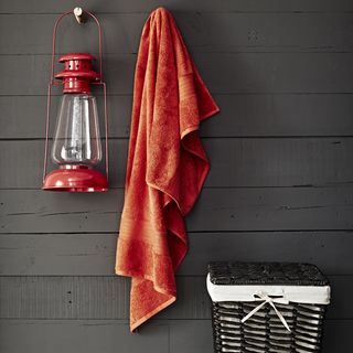 bathroom with hanging red towel and basket