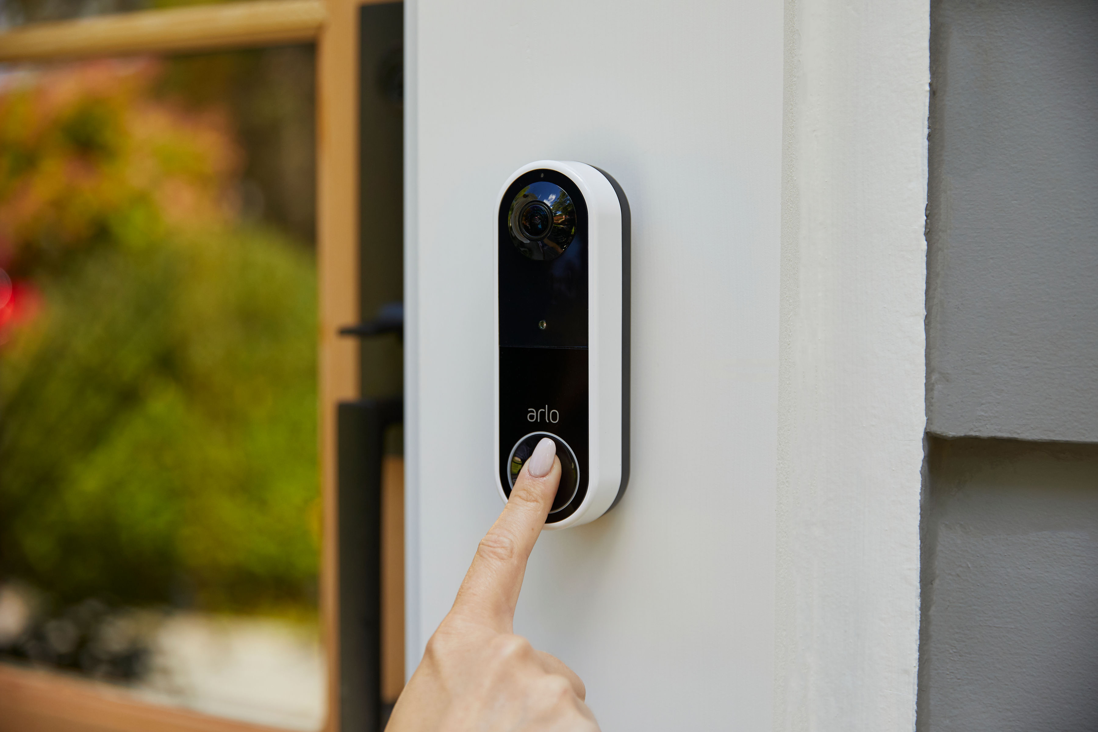 Arlo Video Doorbell en person trykker på dørklokken