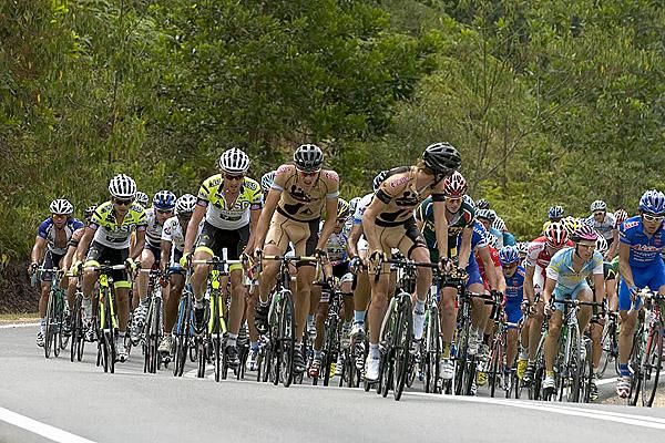The peloton climbing with riders up the road trying to escape.