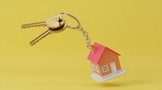 Toy house keychain on yellow background
