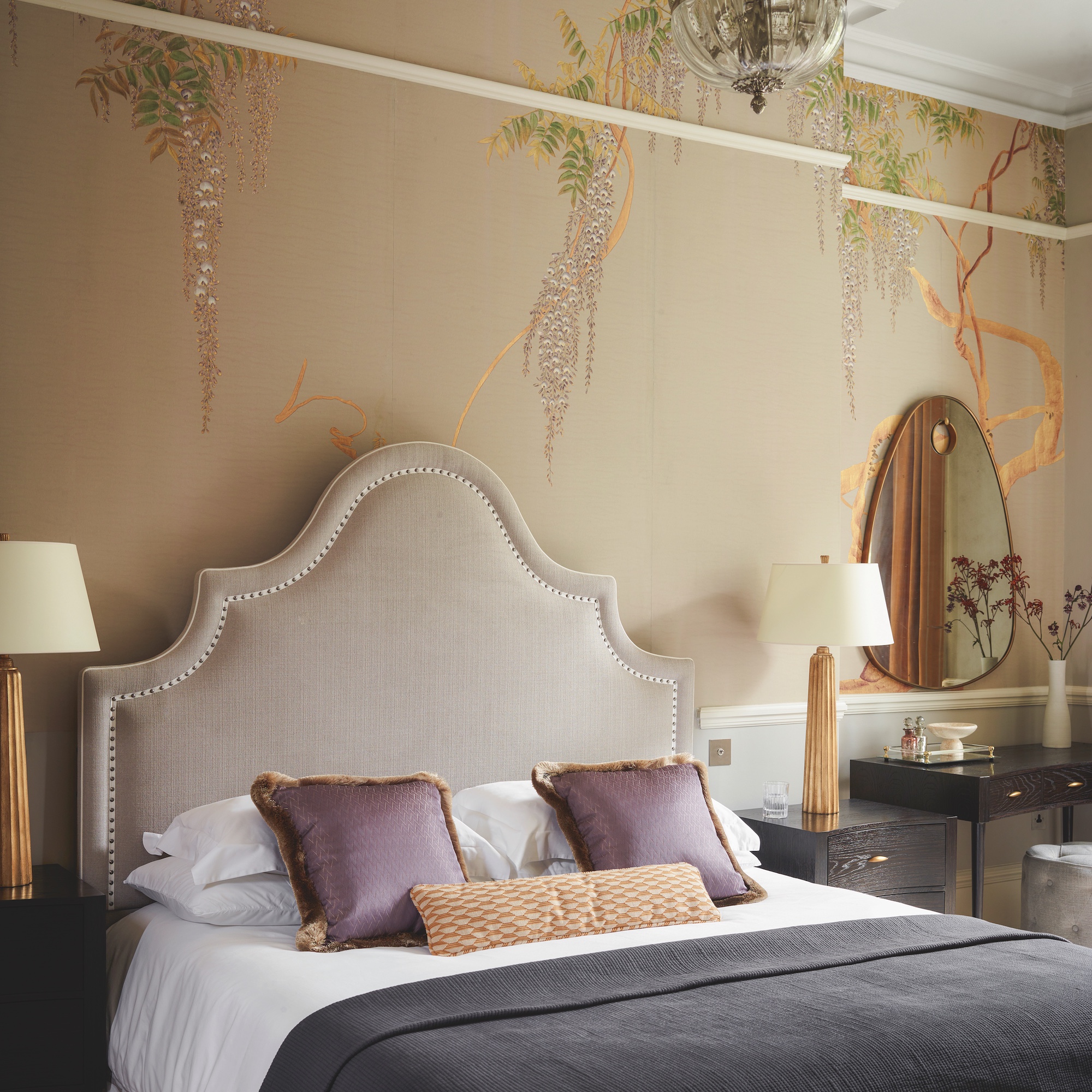 bedroom with shaped upholstered headboard in cream fabric with handpainted wisteria wallpaper