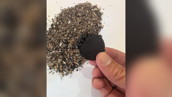 A magnetic disk attracting small pieces of metal, being held by a person