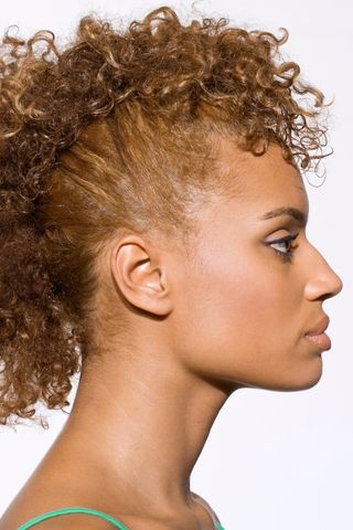 A woman pictured with a curly faux hawk