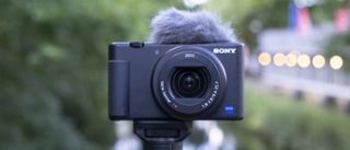 Sony ZV-1 på stativ i grønne, men slørede omgivelser