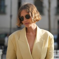 Woman with a warm blonde bob, wearing sunglasses