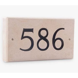 Sandstone house number with black lettering.