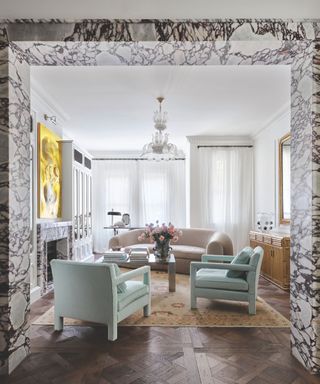 modern living room with dark wood patterned floor and a statement marble door surround with matching fireplace