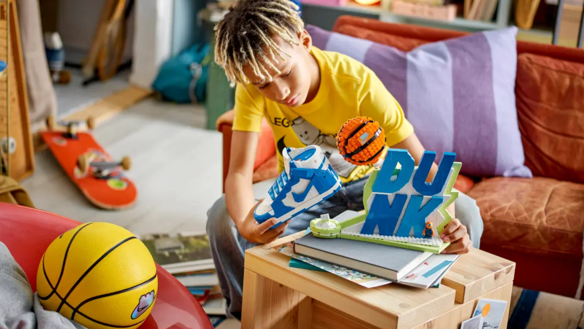 A boy places the Lego Nike Dunk set on a wooden coffee table