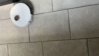 karcher robot vacuum on tiled floor vacuuming oats