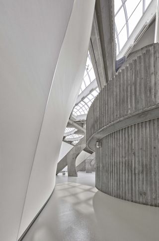Montreal Biodome's texture concrete in its curved stone wall white gallery gallery , view of the ceiling windows casting patterned shadow on the smooth white concrete floor