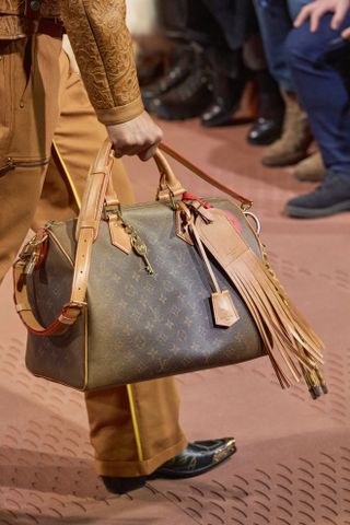 close up shot of Louis Vuitton bag with fringe keychain on runway