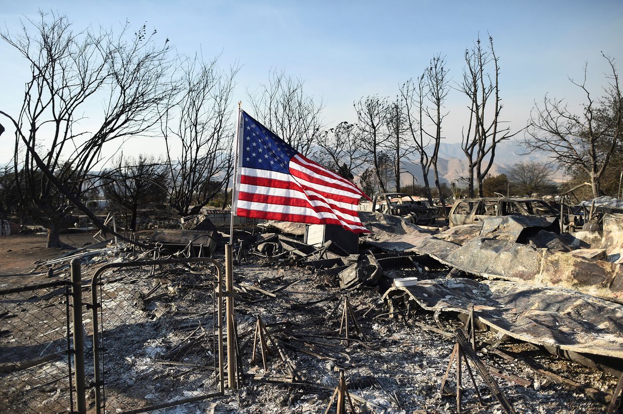 A flag flies above the wreckage left behind from the California wildfire. 