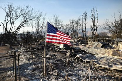 A flag flies above the wreckage left behind from the California wildfire. 
