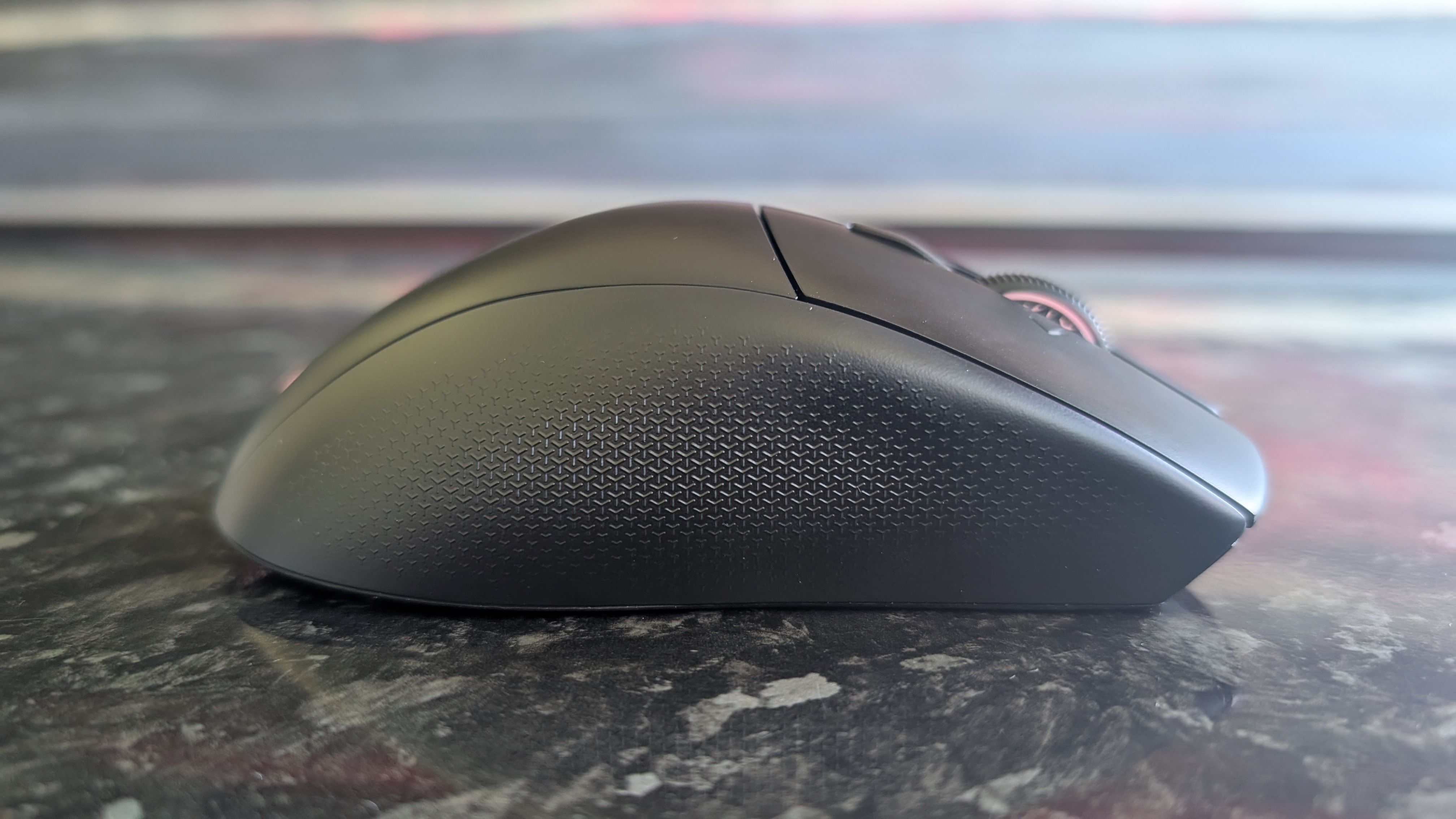 The Corsair Nightsword V2 Wireless gaming mouse pictured on a black marble worktop.