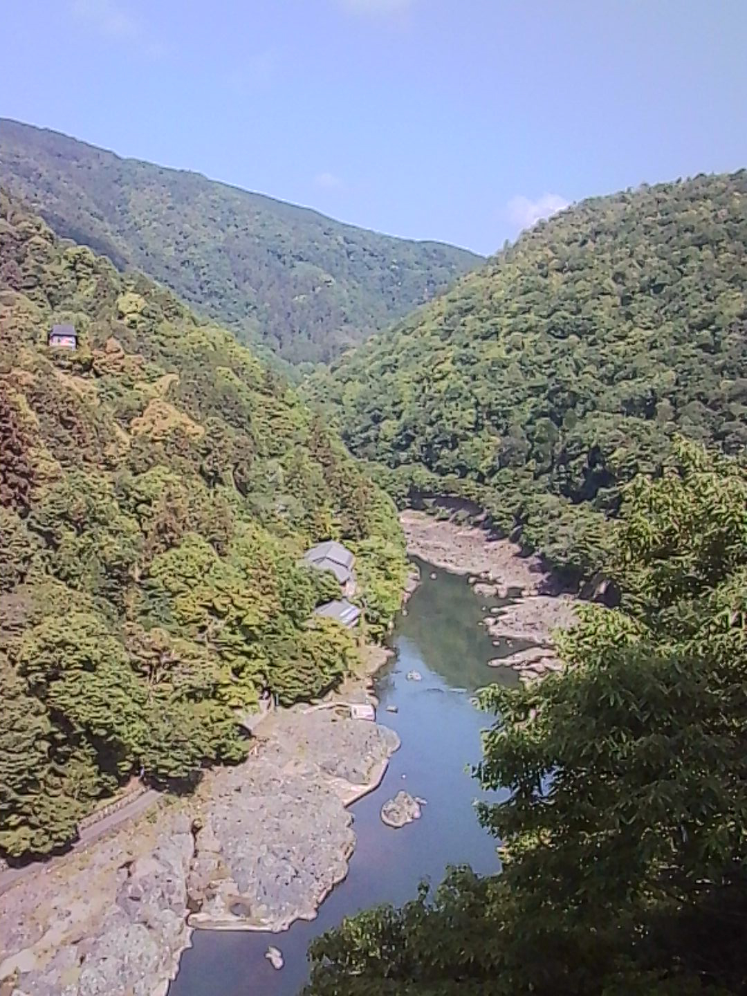 River winding through a green mountain valley in Japan on a sunny day.