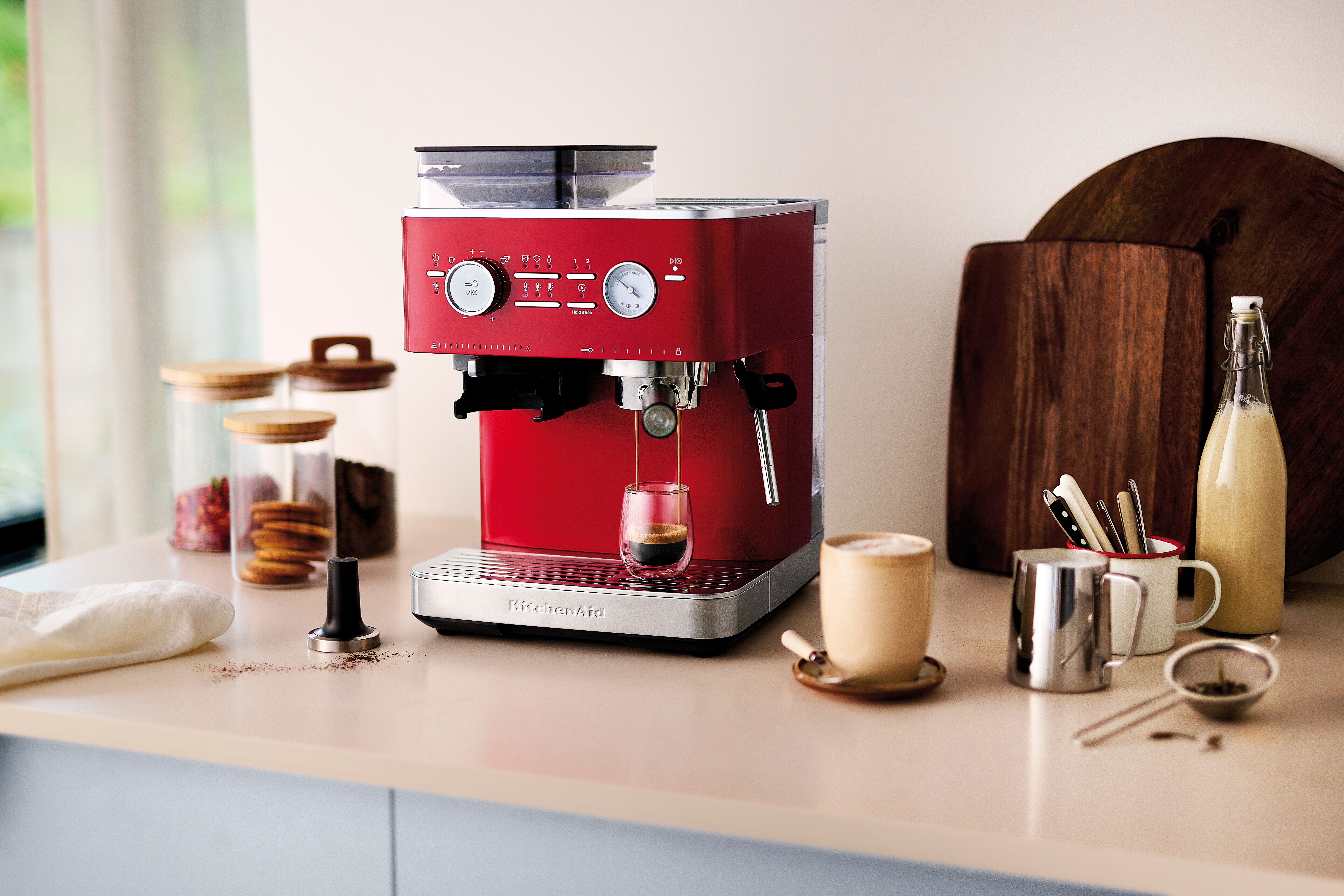 A lifestyle shot of the KitchenAid Semi-Automatic Espresso Machine in the Candy Apple colourway