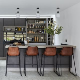 Breakfast bar with leather bar stools and grey cabinets