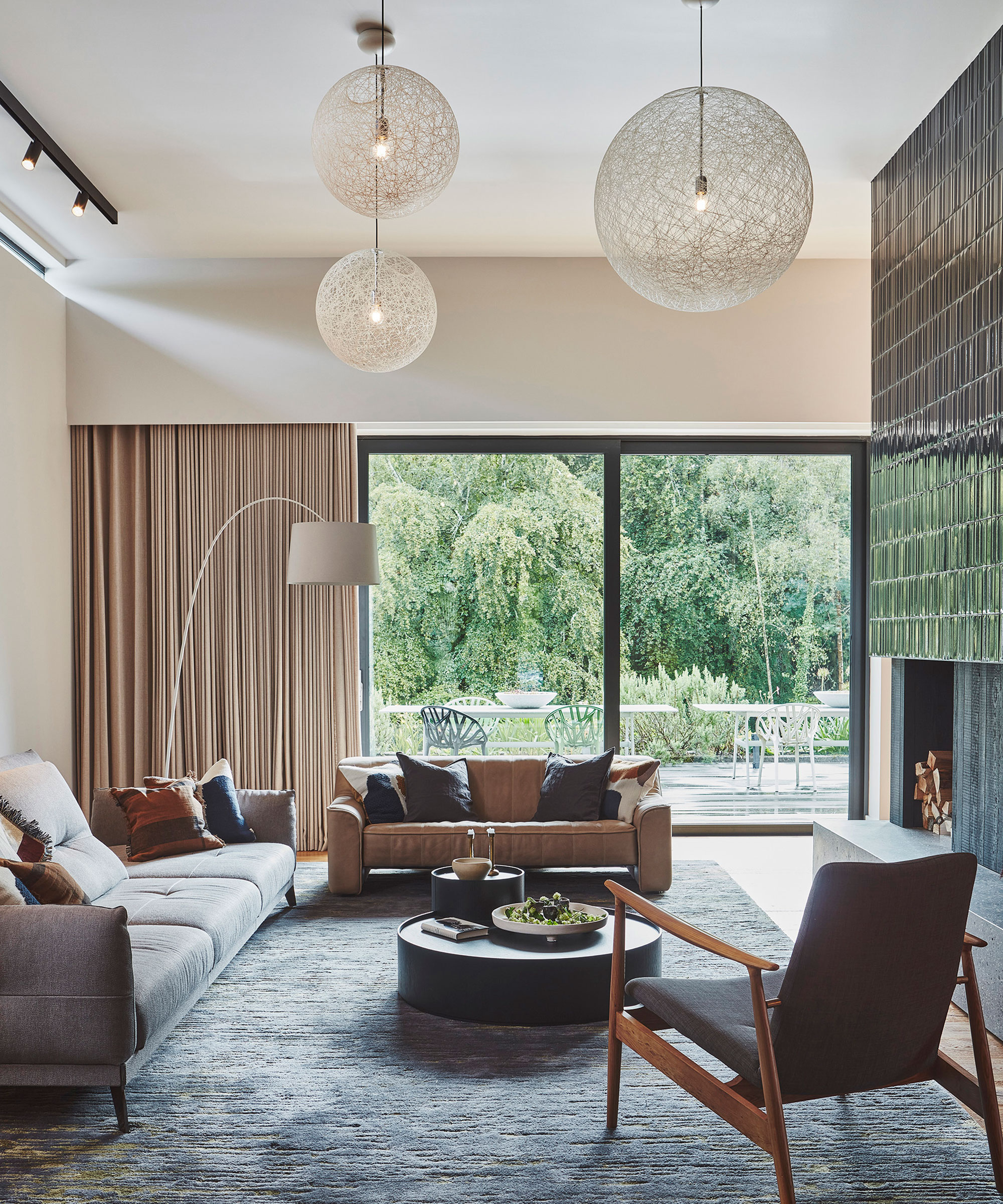 modern living room with green tiled full height fireplace and large sliding doors