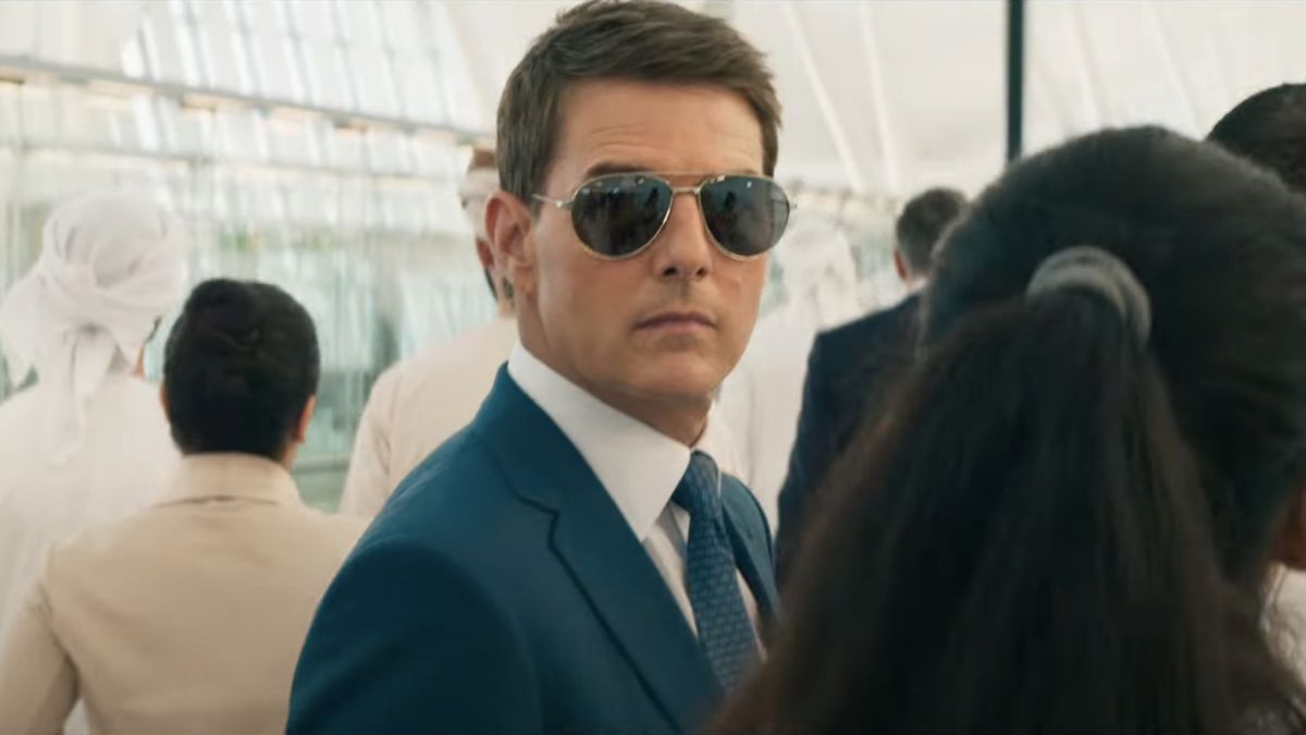 Tom Cruise stands in a crowd wearing sunglasses in Mission: Impossible - Dead Reckoning Part One.