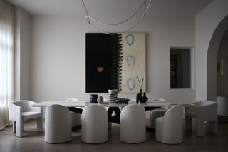 large dining room with 10 seats, artwork, pendant light and neutral color scheme