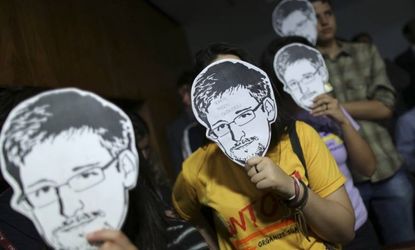 People wear Edward Snowden masks during Glenn Greenwald's testimony before a Brazilian congressional committee on Aug. 6.