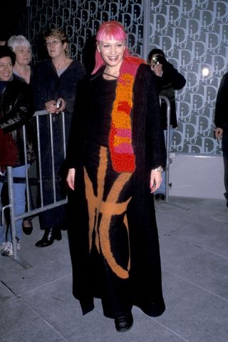 Gwen Stefani wearing a black maxi coat and pink and orange scarf