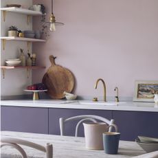 kitchen with lilac walls, purple cabinets, wall shelving and wooden dining table 