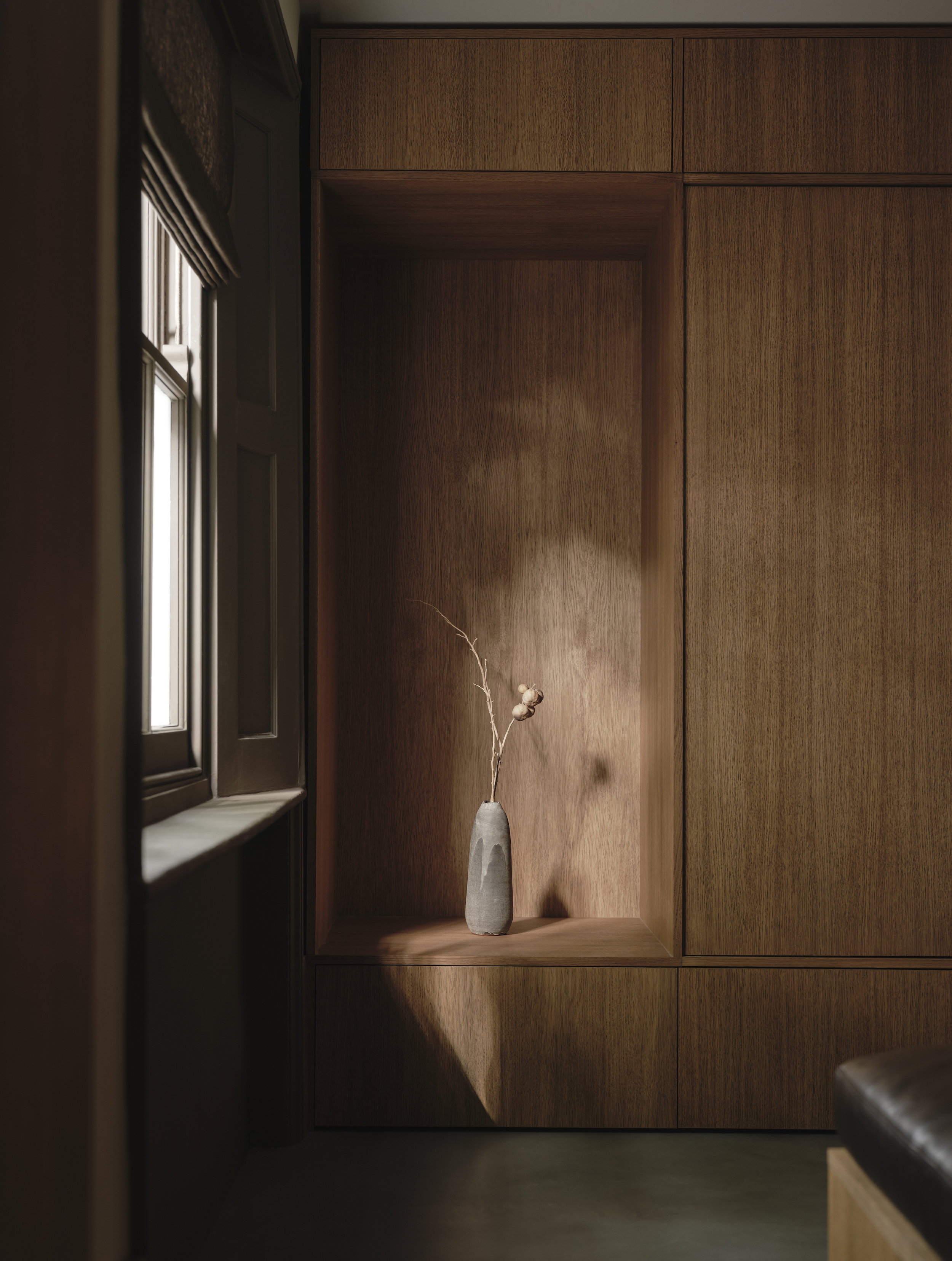 Wooden built-in storage in an entryway with a seat built into it