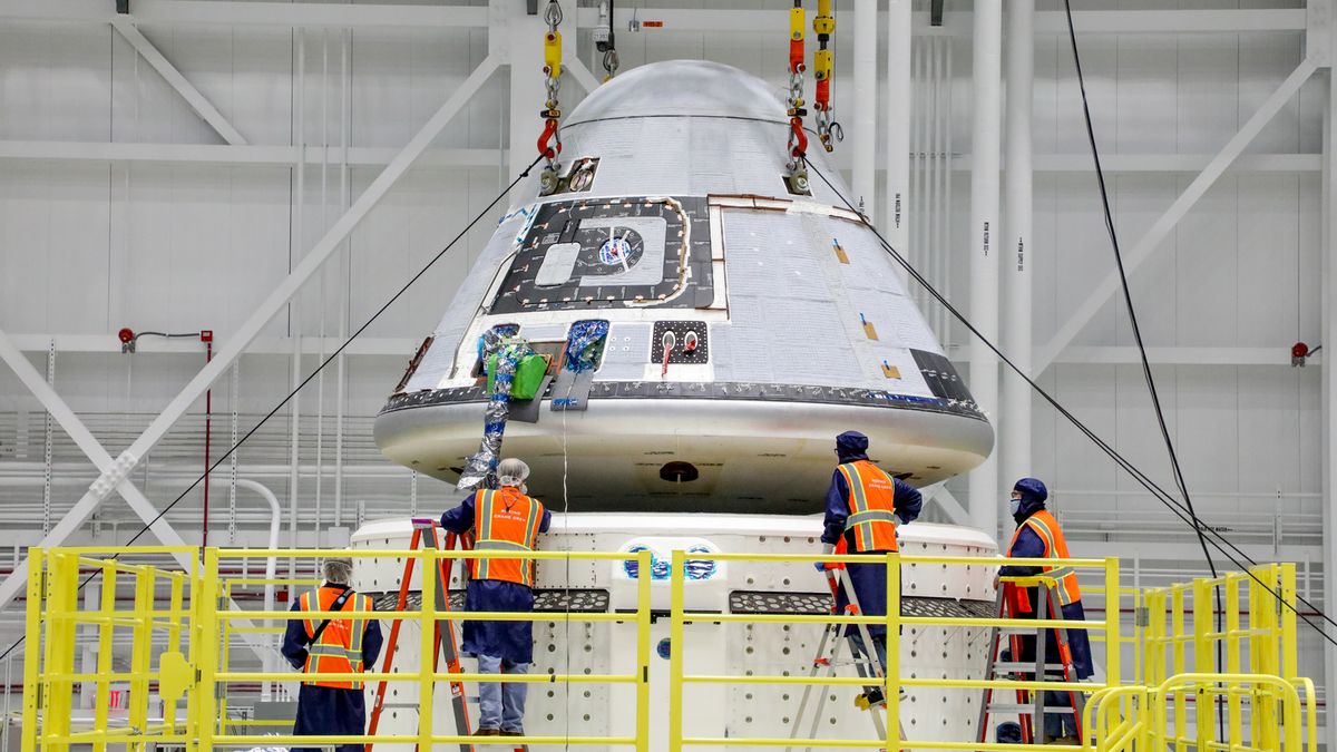 Technicians observe as Boeing&#039;s Starliner crew module is placed on top of the service module in the Commercial Crew and Cargo Processing Facility at NASA&#039;s Kennedy Space Center in Florida, on Jan. 14, 2021. The Starliner spacecraft is being prepared for Boeing&#039;s second Orbital Flight Test (OFT-2).