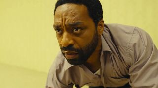 A close up of Chiwetel Ejiofor's Clark looking confused as he crawls through a yellow room in A24's Backrooms movie
