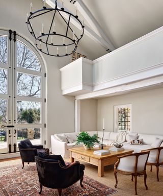 living room with white sofa vaulted ceiling and double height arch topped glass doors