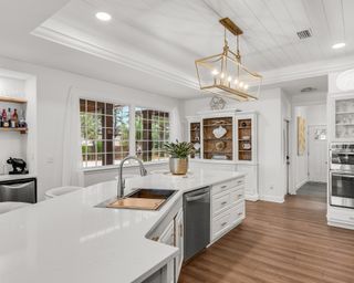 White kitchen beadboard ceilings with gold pendant lighting