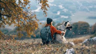 Female hiker next to dog in the mountains