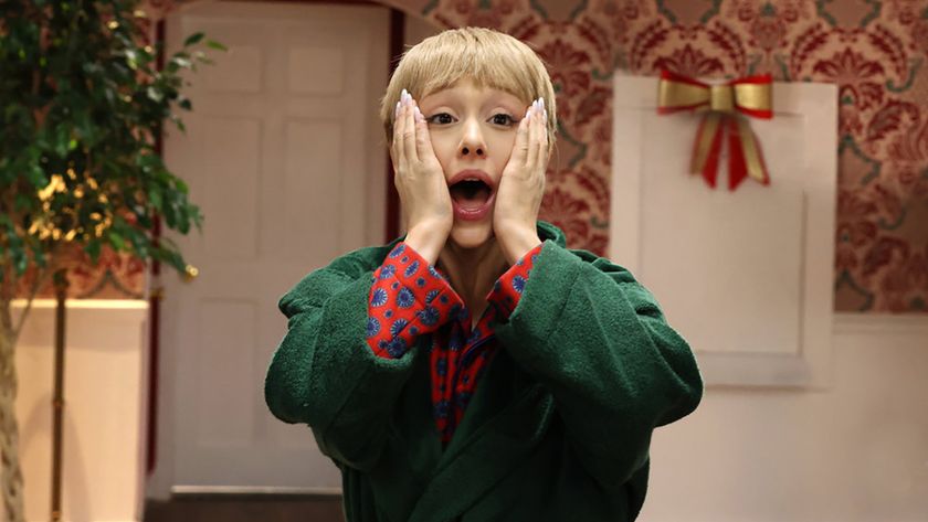 Ariana Grande with the Kevin McAllister hairdo and robe holding her hands to her face in SNL Home Alone sketch.