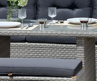 Grey patio set with glass table top and table setting